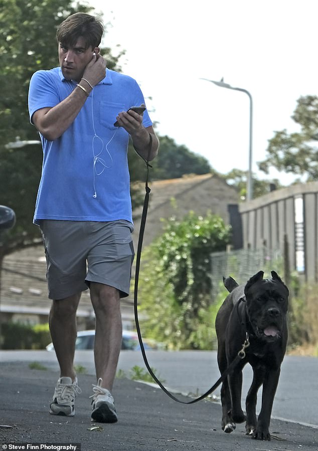 Don't mind me: Jack put in a pair of headphones when he went out with his dog on Thursday