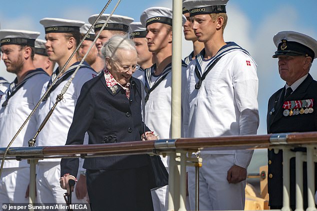 King Carl's cousin Queen Margrethe looked chic in a navy blue coat and red and white dress underneath