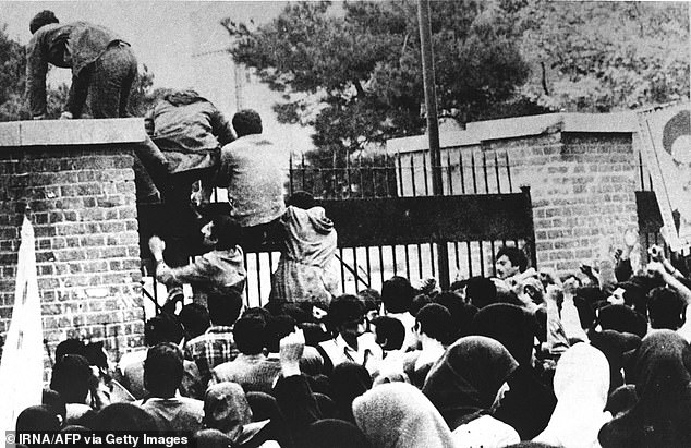 A file photo taken on November 4, 1979 shows Iranian revolutionary students climbing the gate of the US Embassy in Tehran.  It took 444 days for the crisis to end with the release of 52 Americans, but the US broke off diplomatic ties with Iran in 1980 and ties have been frozen ever since.