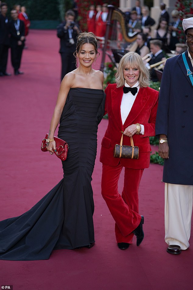 Fashionable friends: Twiggy swapped heels for black loafers and beamed as she posed with Rita Ora on the star-studded red carpet