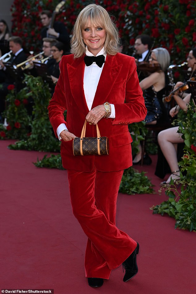 Ensemble: She paired her chic suit with a black bow tie and white shirt and carried a classic Louis Vuitton bag