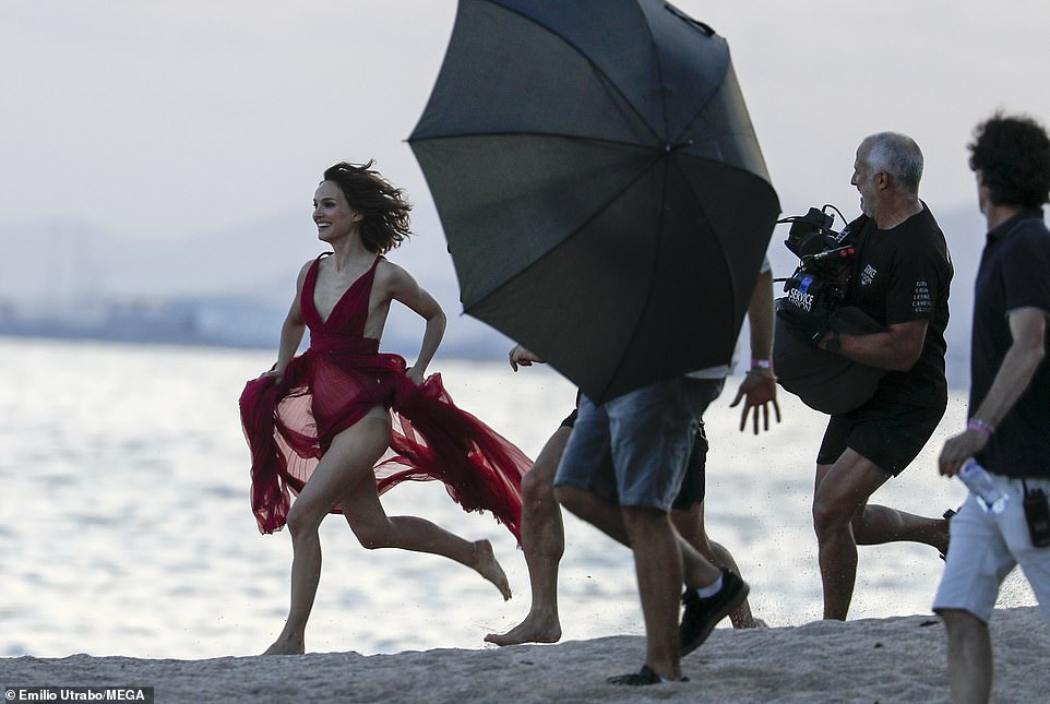 Frolicking on the beach: While surrounded by production crew and filming, the Black Swan star - who looked glum as she stepped out without her wedding in Paris two days earlier - ran along the seafront