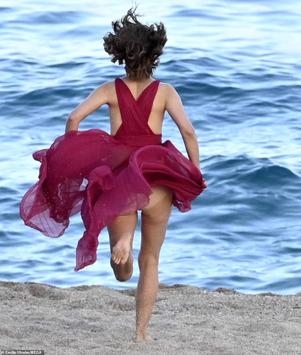 Running: She was seen at one point sprinting towards the water, her hair and dress flying wildly behind her