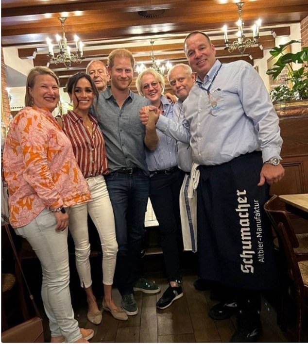 The Duke and Duchess of Sussex celebrated Harry's 39th birthday at a German beer house.  Pictured: The Sussex's with restaurant owner Thea Ungermann and head waiter Frank Wackers