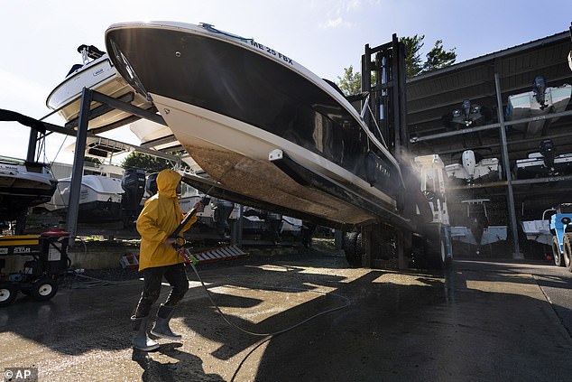 The hull of a boat is cleaned after it was pulled from the water ahead of Hurricane Lee at York Harbor Marine, Thursday, September 14, 2023, in York, Maine