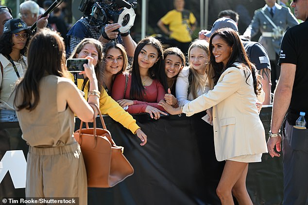 Meghan appeared happy to pose for photos with the gathered crowd as she attended the Invictus Games in Dusseldorf today