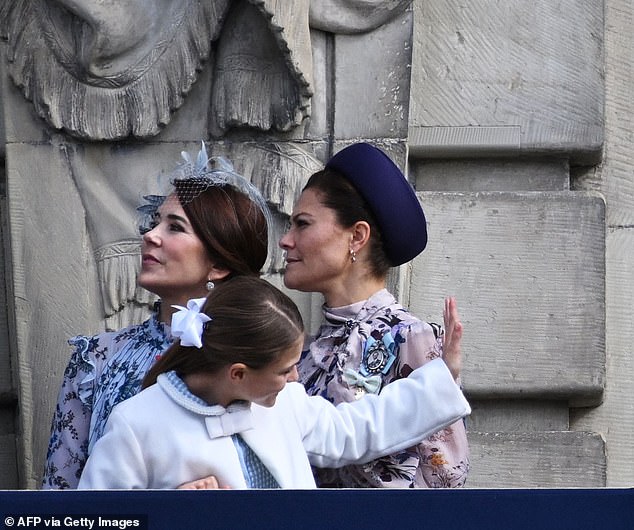 She completed her ensemble with a feathered fascinator in a complementary shade of blue and carried a navy blue clutch