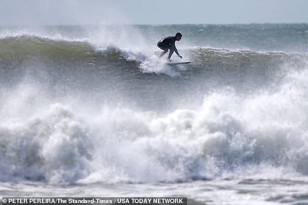 A brave surfer rides the monster waves at Horseneck Beach in Westport, Massachusetts, on Friday