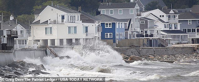 Waves crash against the seawall in the Sand Hills district of Scituate, south of Boston, Massachusetts