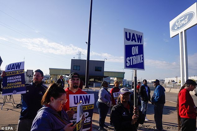 Workers stand outside the Ford Michigan assembly plant Friday