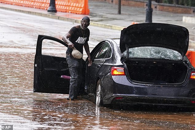 Bernard Johnson retrieves his belongings from his flooded rental car in downtown Atlanta