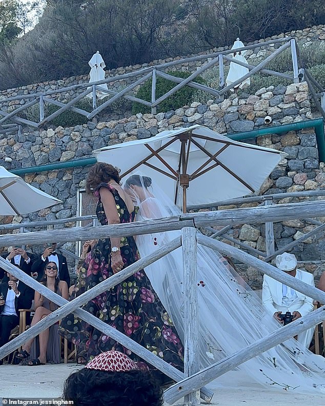 One of the photos Jess shared showed Katie walking down the aisle with a huge white veil behind her, embroidered with flowers and stems.