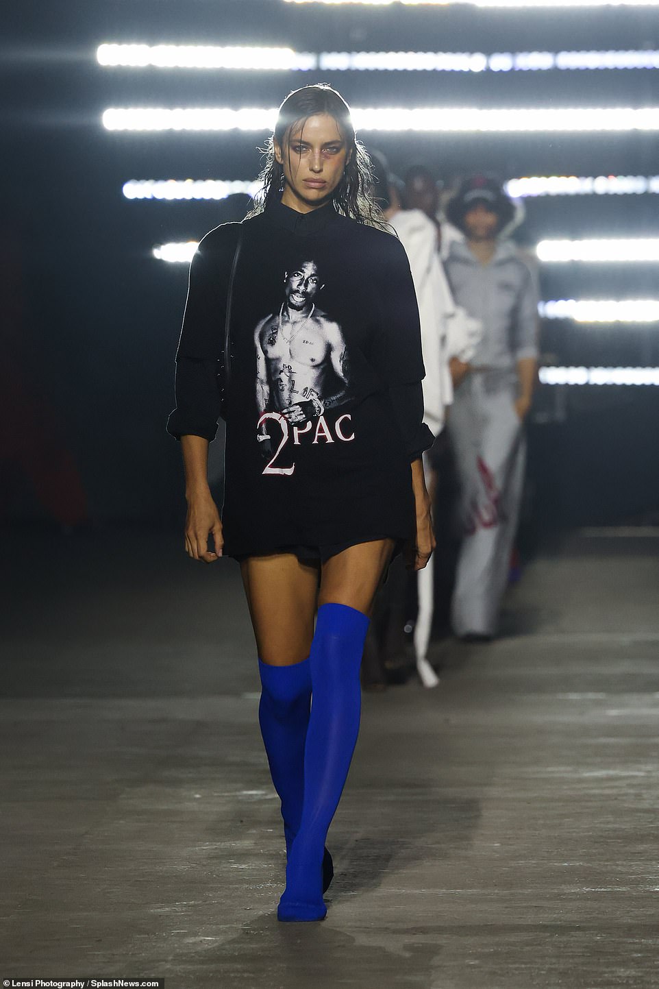 All hail the king: The Marc Jacobs runway model showed off her sculpted legs in her second outfit, wearing a 2Pac T-shirt and her long, thigh-high blue boots