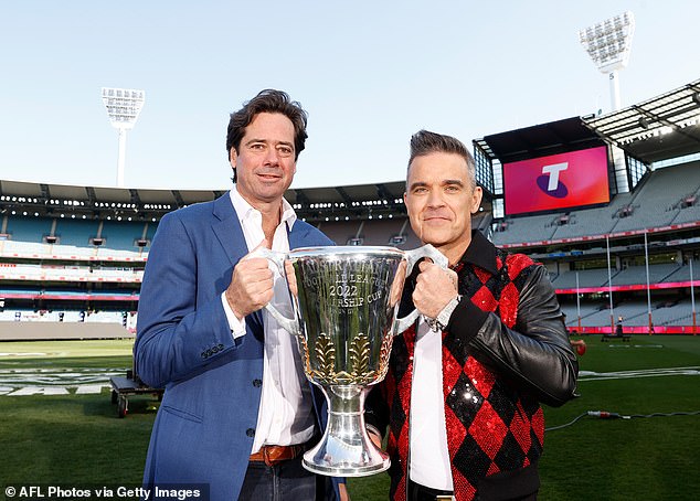 AFL boss Gil McLachlan and Williams pose for a photo with the AFL trophy ahead of last year's big match