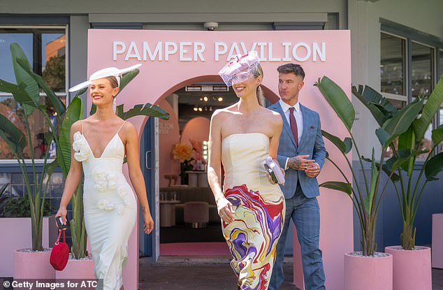 The television presenter smiled as she enjoyed her day out at the races and appeared to spend a lot of time with fellow model Jordan Simek, 27, (left)