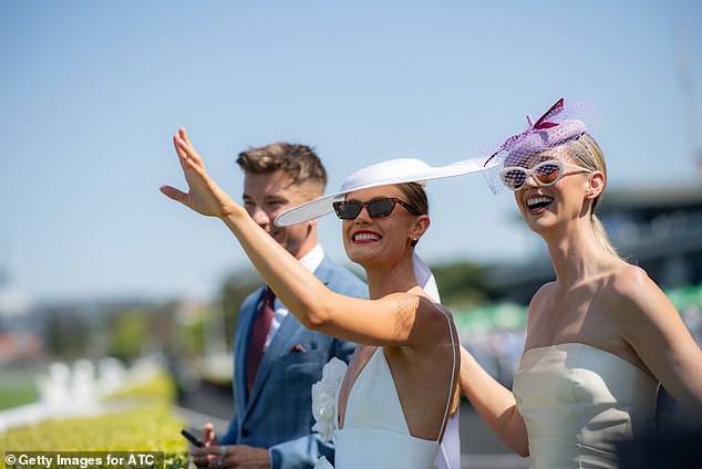 The blonde beauty rocked a bold red lip for the occasion and wore an incredibly wide-brimmed fascinator that hung low over her face.