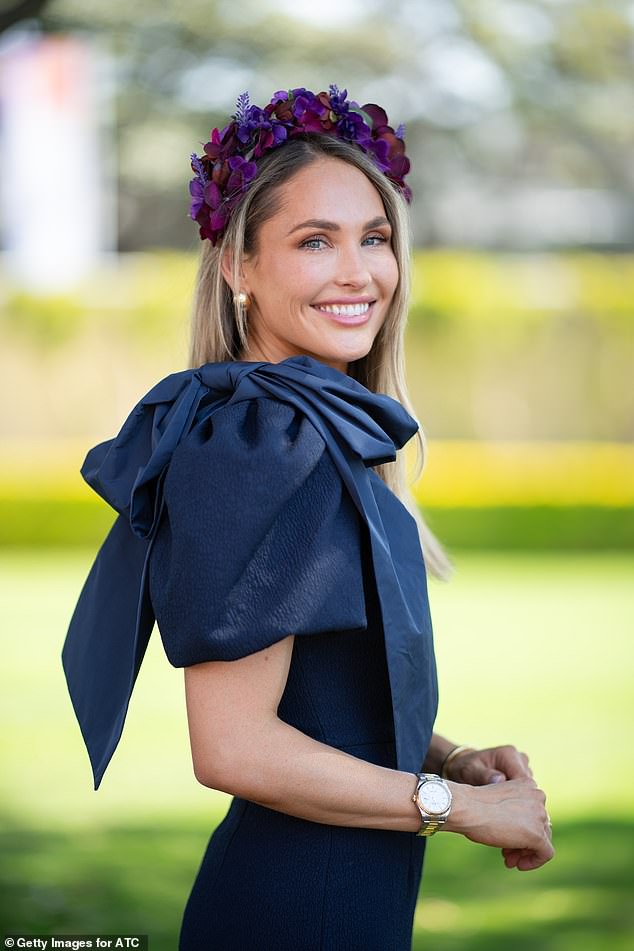 A subtle purple floral fascinator kept her blonde locks slicked back while the beauty opted for a natural makeup look