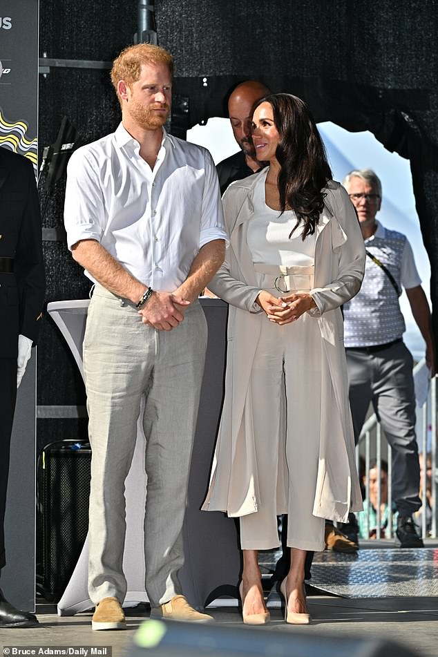 Meghan (right) dazzled in a Cuyana jacket and pants, paired with a white tank top and Lanvin earrings