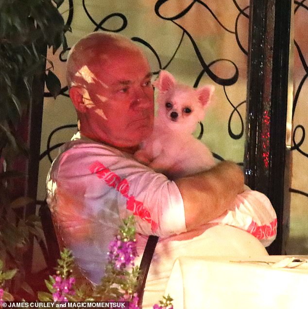 True love: The adorable pooch looked alert in his owner's arms as Damien held the dog close to his chest and snuggled up to his pet