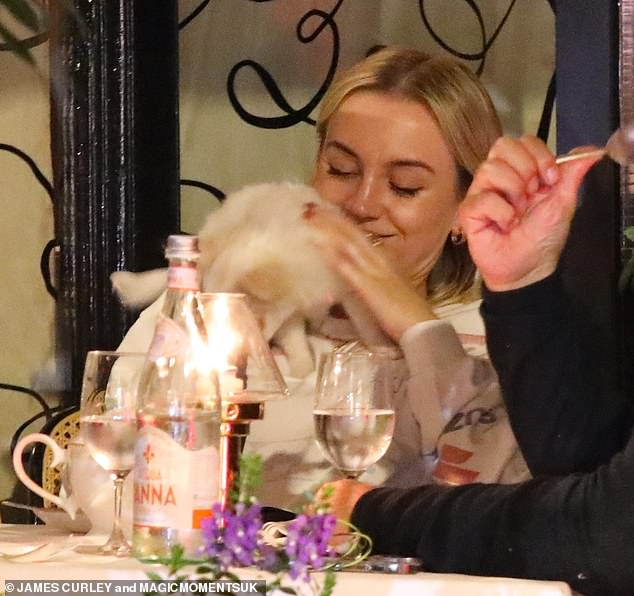 Proud mum: Sophie also smiled as she held and petted the dog during the meal