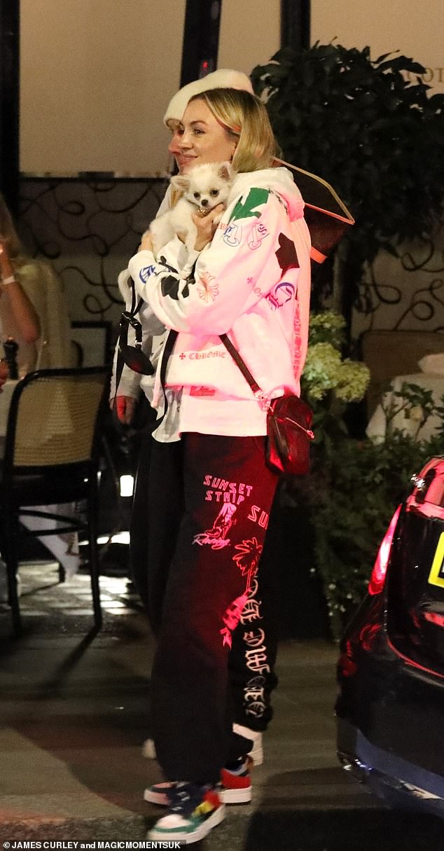 Twinning: The pair appeared to be wearing matching outfits as they both wore black track pants and white hoodies with a graphic lettering pattern