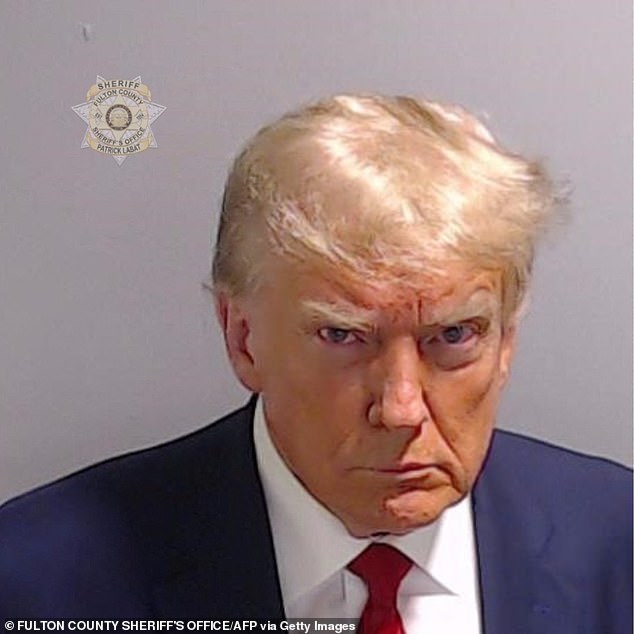 Former United States President Donald Trump poses for a mugshot, holding a postage stamp that reads 'Fulton County Sheriff's Office'