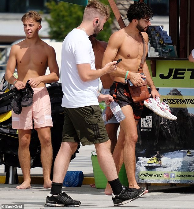 Jet ski time: He put his abs on full display as he strolled around the island and had a conversation with his friends before heading out to rent a jet ski for the day