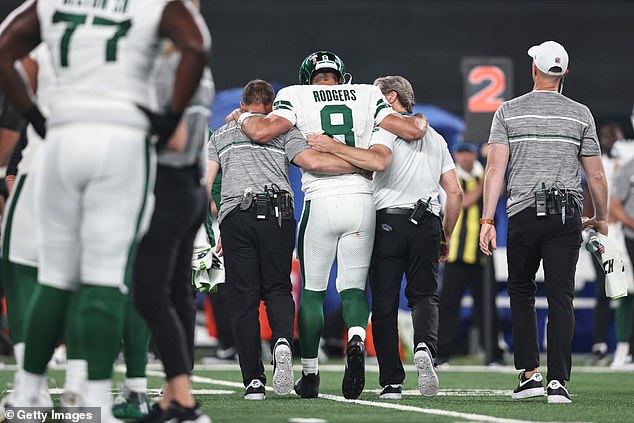 Aaron Rodgers is helped off the field by the New York Jets trainers at MetLife on Monday evening