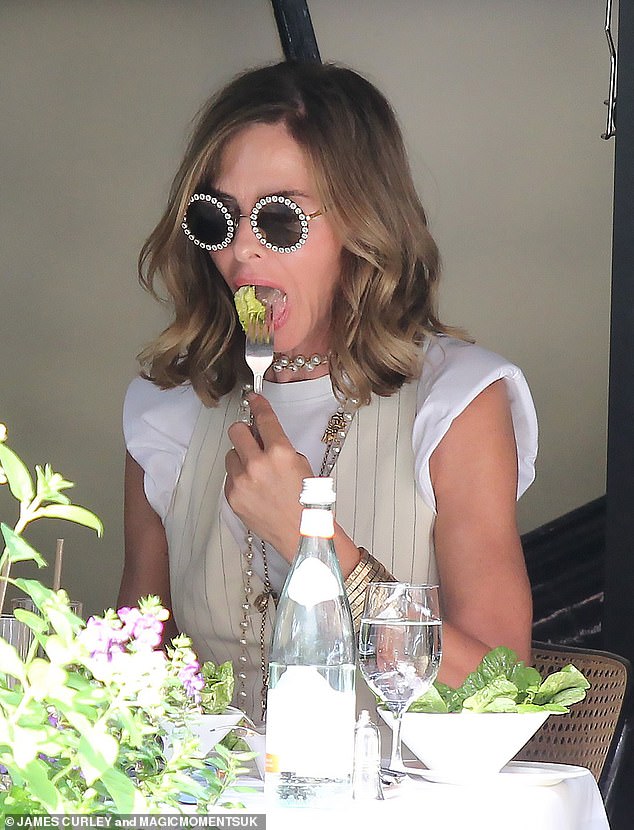 Yum: Trinny seemed to leave her slit behind as she tucked into a tasty salad with a bottle of water nearby to quench her thirst