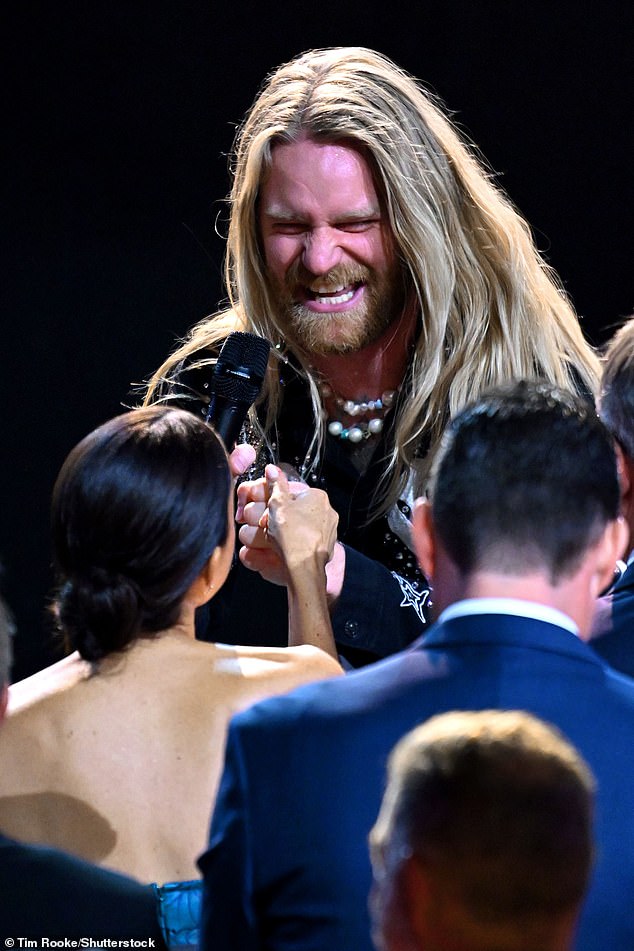 The British Eurovision winner was seen smiling and holding Meghan's hand as he performed