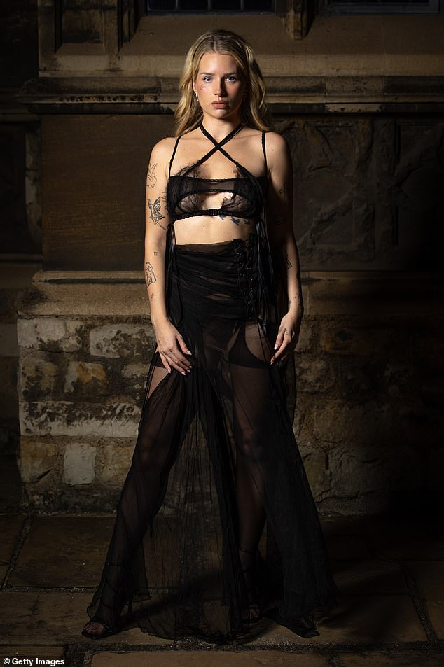 Breathtaking: Lottie, 25, wore a breathtaking ensemble that consisted of black stockings and a barely-there skirt with a sheer lingerie-style top