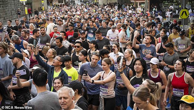 Runners take photos as they hit the pavement for the Sydney Marathon on Sunday