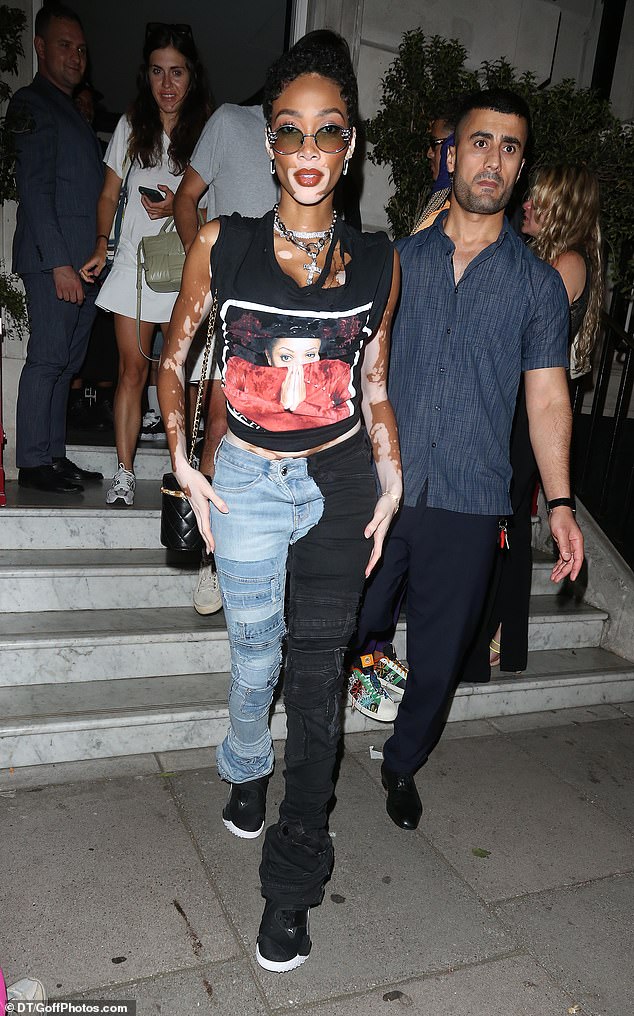 Fab: Winnie, 29, looked edgy in a Janet Jackson band style T-shirt and split jeans as she left the private members club