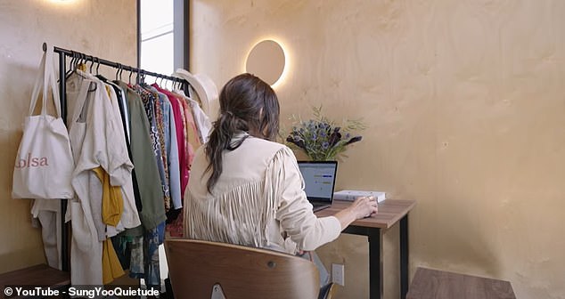 Her office-dining room consists of a desk and swivel chair, while a rail next to it showcases the rest of her wardrobe