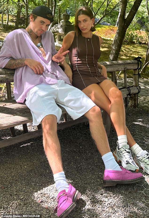 Chilling: Justin then shared a photo of himself relaxing next to Hailey in a public park