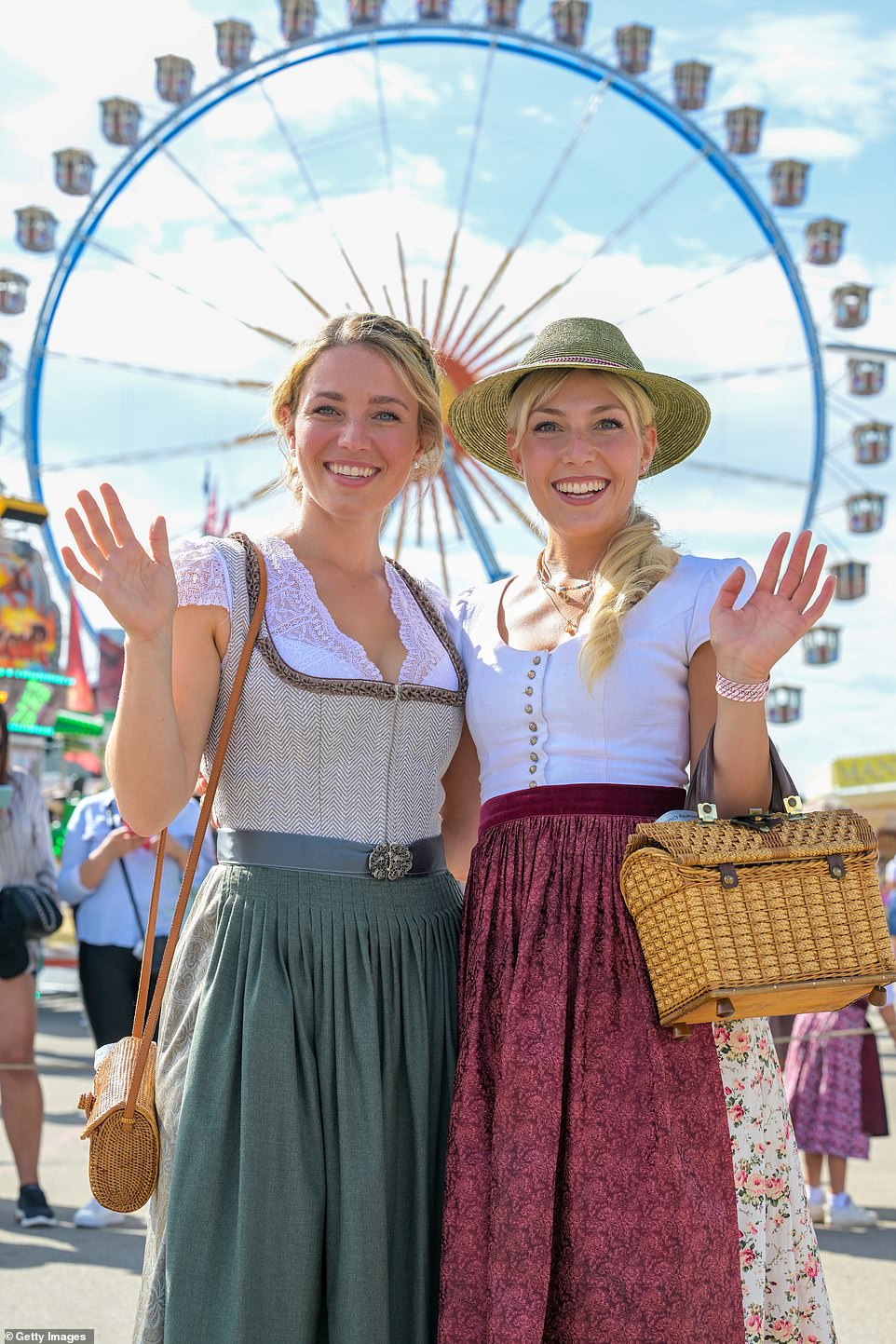 Two women dressed in traditional 'dirndls', a traditional dress consisting of a bodice with a low neckline, a blouse and a high-waisted skirt