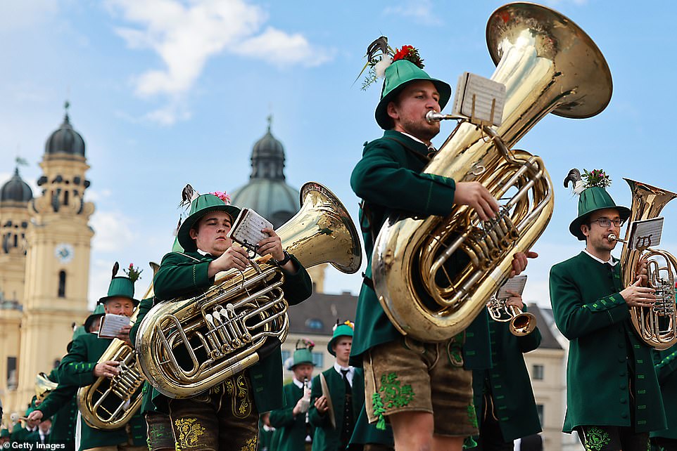 Members of a traditionally dressed costume group play in a marching band during the shooting parade