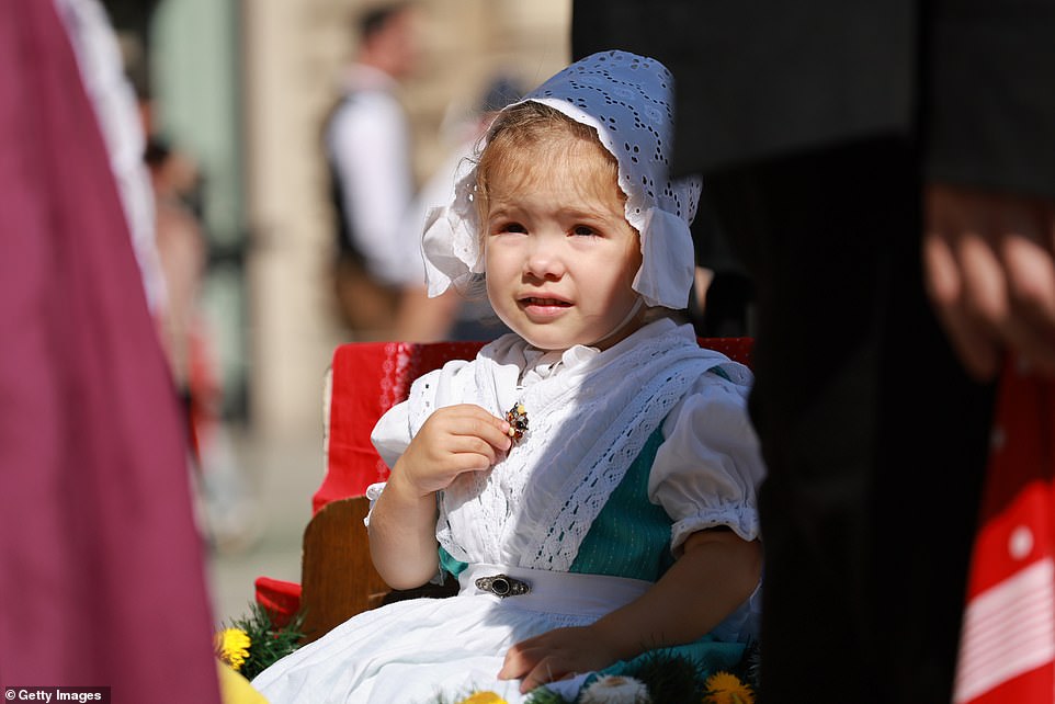 A young girl in traditional clothing takes part in the shooter's parade on the second day of the Munich Oktoberfest in 2023