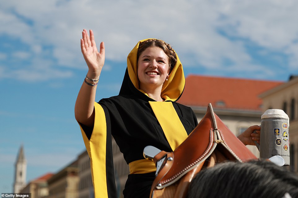 A young woman performing the so-called 'Muenchner Kindl', which means 'Munich child', rides a horse during the shooting parade