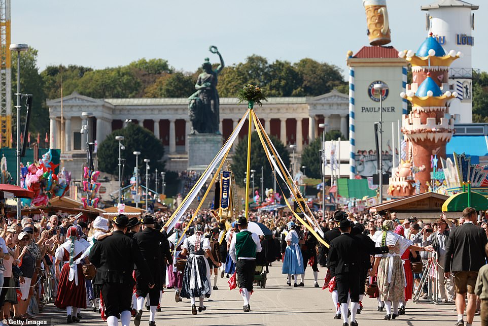 People in traditional clothing walk in a parade while others take part in maypole dances