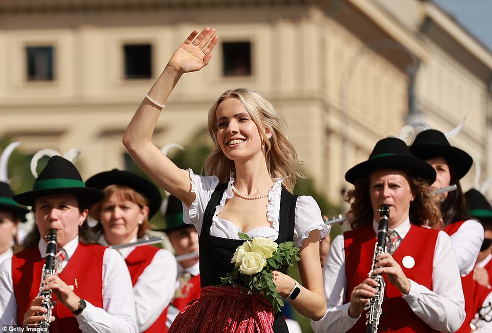 A young woman in traditional clothing is accompanied by a brass band during the gunmen's parade earlier today