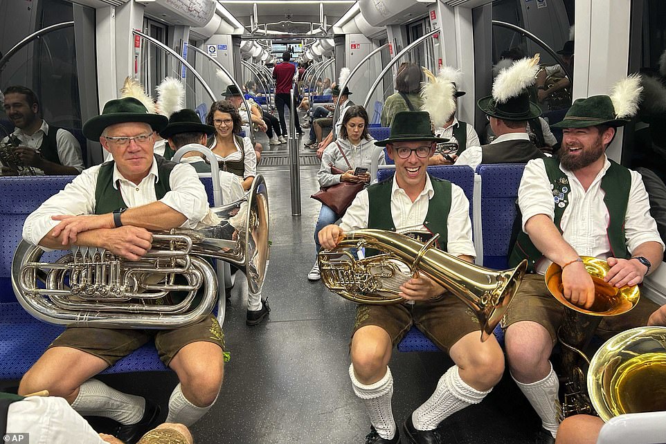 Bavarian musicians sit in the subway on their way to a traditional costume and shooting parade