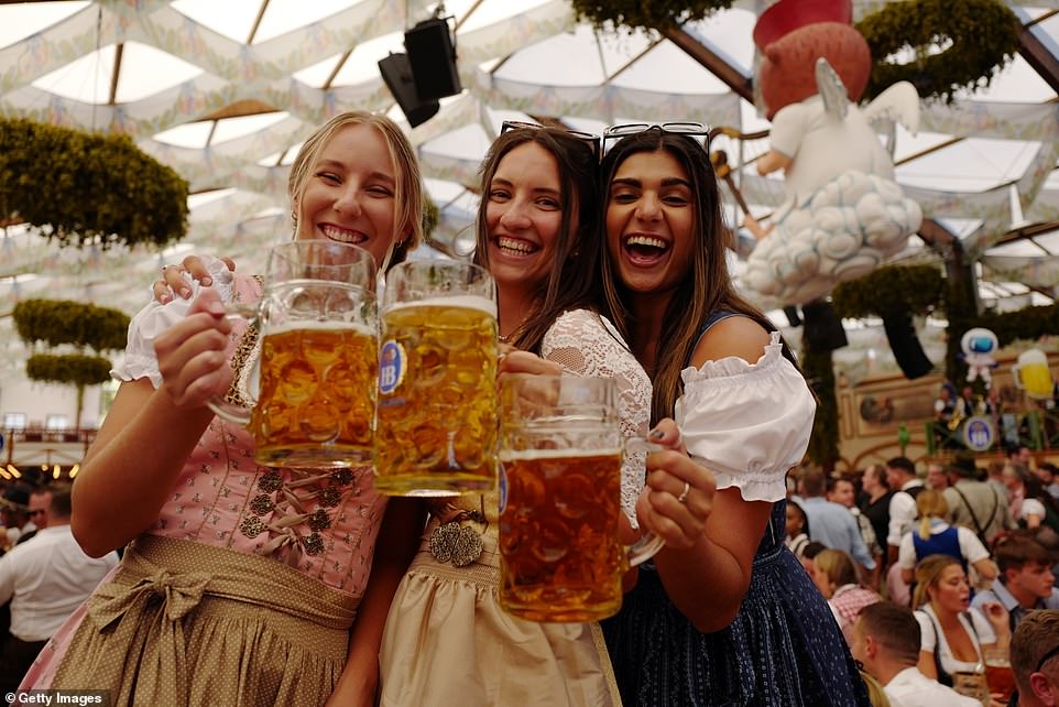 Revelers drink beer from traditional beer steins in the Hofbraeu tent on the opening day of the Munich Oktoberfest 2023