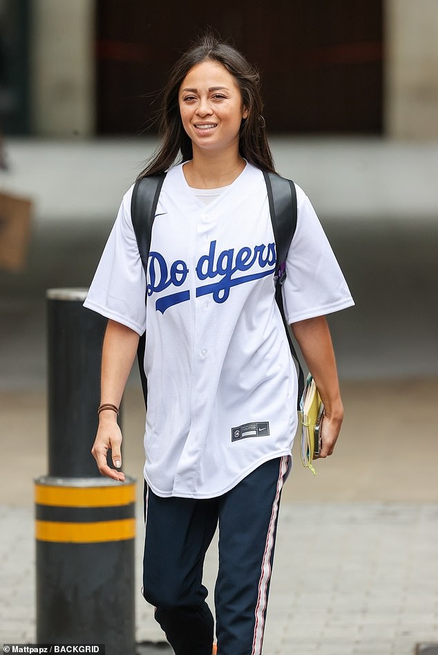 Sporty: The star looked chic in the trendy basketball-inspired T-shirt with a pair of white and black pinstripe joggers