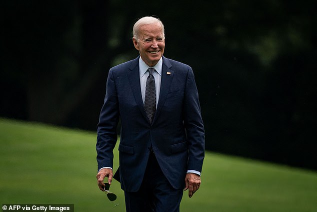 President Joe Biden smiles as he walks past reporters on the South Lawn Sunday after spending the weekend in Wilmington, Delaware