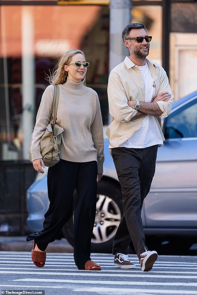 Cozy: The 33-year-old No Hard Feelings actress looked ready for fall in a beige turtleneck, comfy black pants and fluffy brown slippers