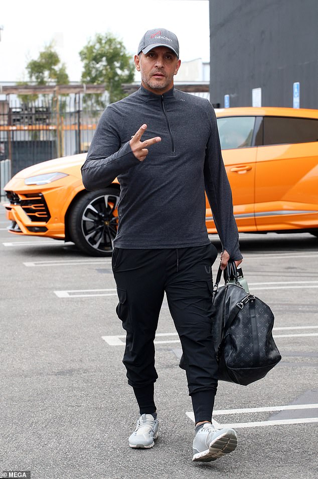 The Buying Beverly Hills personality showed photographers a peace sign as he entered a practice facility