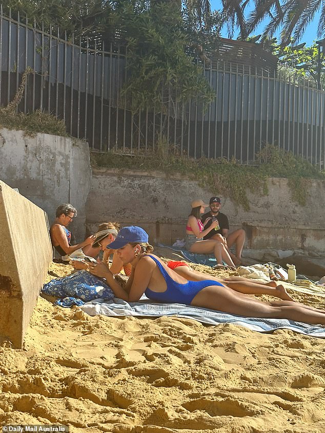 She was seen sitting upright for a while while listening to music, before lying on her stomach to ensure her backside was sufficiently bronzed.