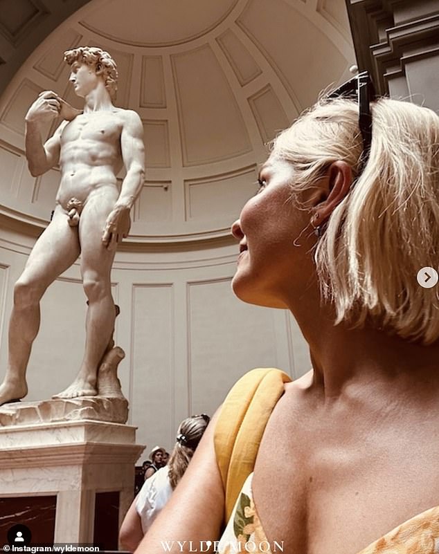 Naughty: Holly also shared a cheeky photo of herself looking up at Michelangelo's naked David statue in Florence's Accademia gallery