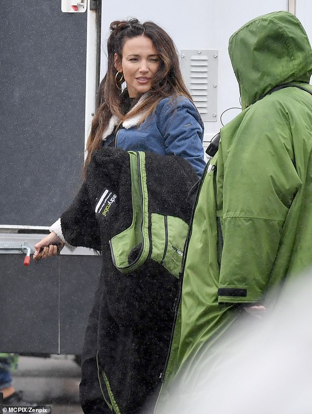 Stunner: Michelle beamed at her colleague as she walked into the trailer for her day back on set - although it's not known whether she was shooting series six or a special